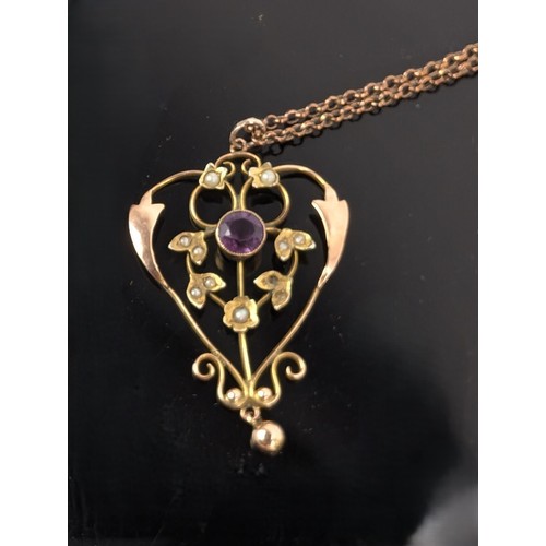 60 - A 9ct gold Art Nouveau pendant set with an amethyst and seed pearls, fashioned as flowers in a 9ct g... 