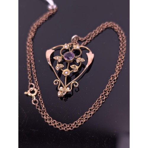 60 - A 9ct gold Art Nouveau pendant set with an amethyst and seed pearls, fashioned as flowers in a 9ct g... 