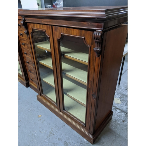 192 - An unusual three-section Victorian mahogany breakfront bookcase, the centre section of seven drawers... 