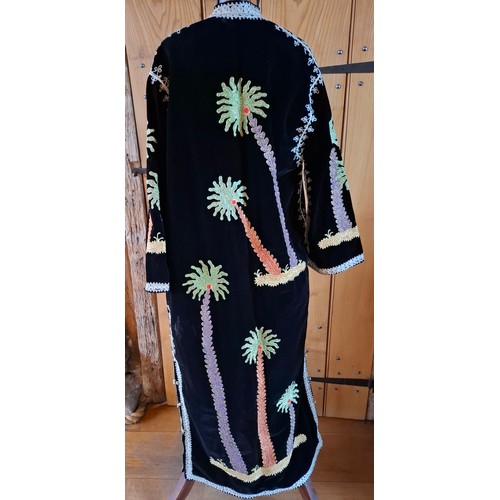 71 - A 1970's Asian black velveteen and embroidered robe having images of palm trees embroidered with met... 