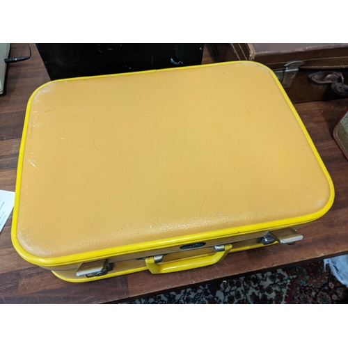 256 - A group of vintage containers to include two suitcases, a metal box labelled FHU Finch, a single rec... 