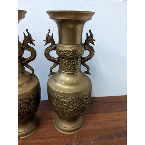 439 - A pair of Oriental brass urns with twin handles fashioned as dragons, approx. 40cm high Location: GM... 