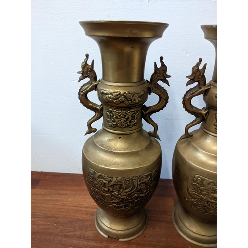 439 - A pair of Oriental brass urns with twin handles fashioned as dragons, approx. 40cm high Location: GM... 