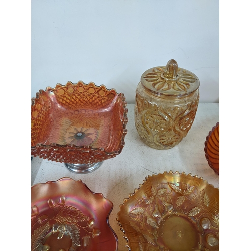 503 - A collection of mostly orange carnival glass to include bowls, dishes and a lidded pot, along with v... 