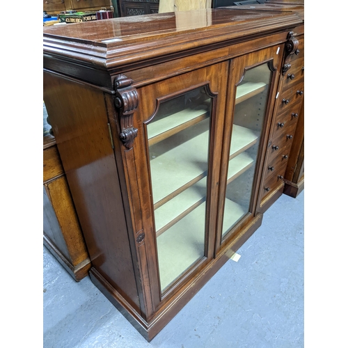 192 - An unusual three-section Victorian mahogany breakfront bookcase, the centre section of seven drawers... 