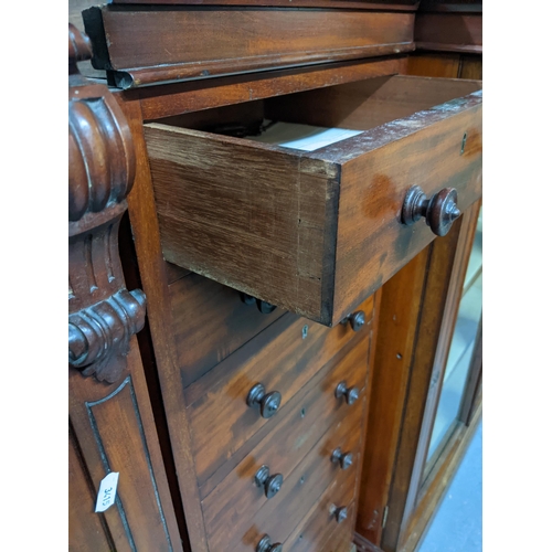 192 - An unusual three-section Victorian mahogany breakfront bookcase, the centre section of seven drawers... 