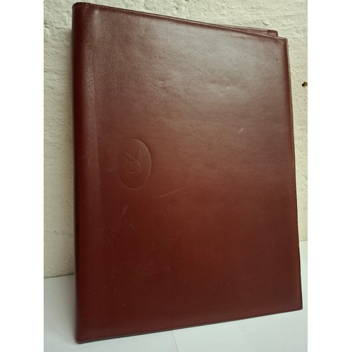 23 - Cartier - A burgundy leather stationary folio with Playboy pressed insignia to the front and Playboy... 