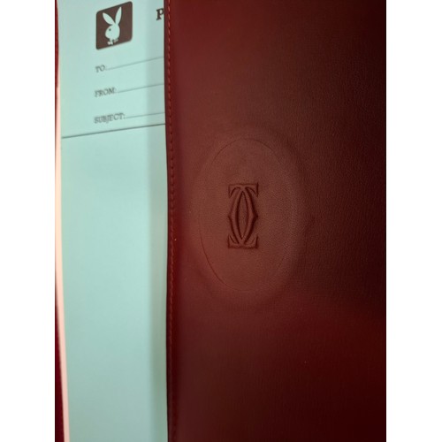 23 - Cartier - A burgundy leather stationary folio with Playboy pressed insignia to the front and Playboy... 