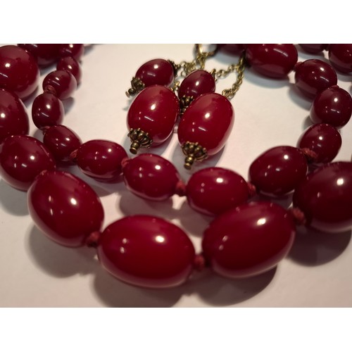 40 - A vintage cherry amber resin suite comprising a necklace of 47 graduating beads, approx 91cm in leng... 