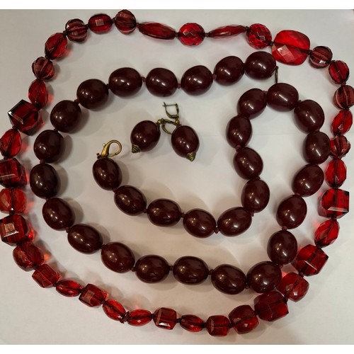 41 - A vintage cherry amber resin suite comprising a necklace of 31 large oval beads, approx 87cm total l... 