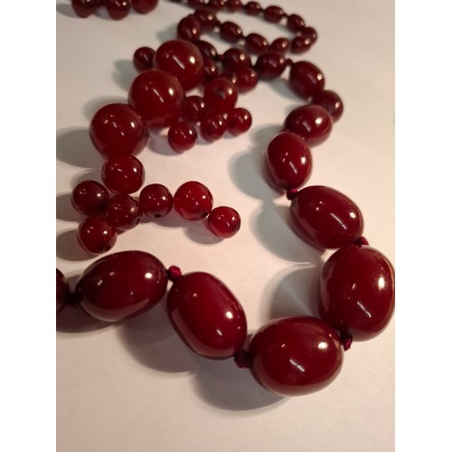 42 - Two vintage cherry amber resin necklaces, one A/F consisting of approx 34 beads, the other having a ... 