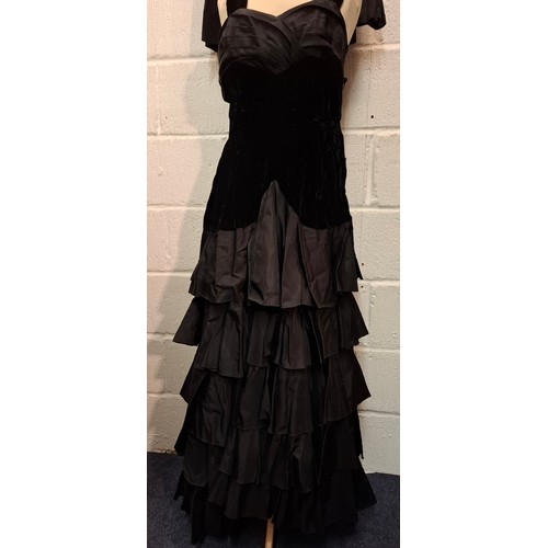 93 - A vintage black velvet and taffeta evening gown with tiered skirt together with a detachable multi l... 