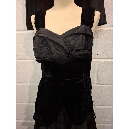 93 - A vintage black velvet and taffeta evening gown with tiered skirt together with a detachable multi l... 