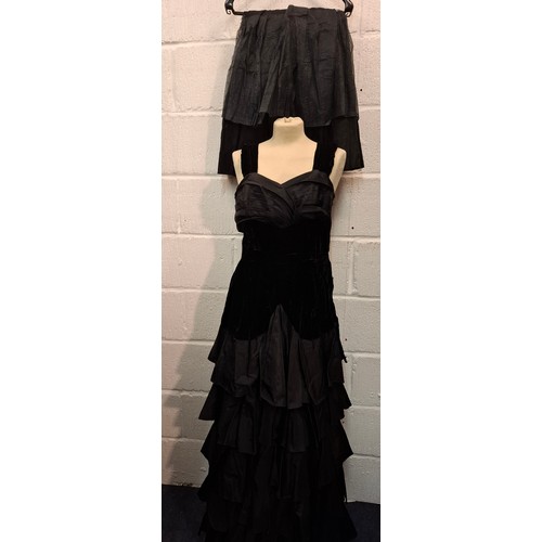 93 - A vintage black velvet and taffeta evening gown with tiered skirt together with a detachable multi l... 