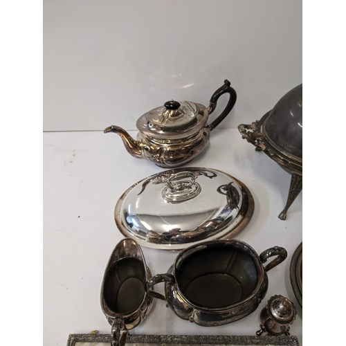 155 - A collection of silver plated items to include a breakfast dish with a hinged lid and four legs, a t... 