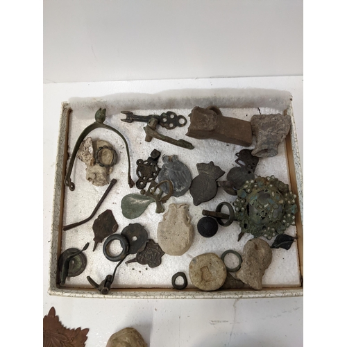 176 - A collection of metal detector finds to include bells, a boot strap, a thimble, a brooch and other i... 