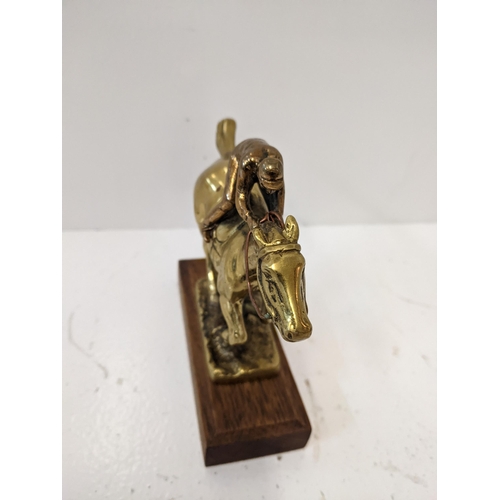 184 - A brass sculpture of a horse and jockey, mounted on a wooden plinth 
Location: A2F
If there is no co... 