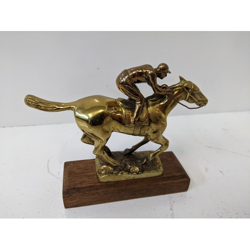 184 - A brass sculpture of a horse and jockey, mounted on a wooden plinth 
Location: A2F
If there is no co... 