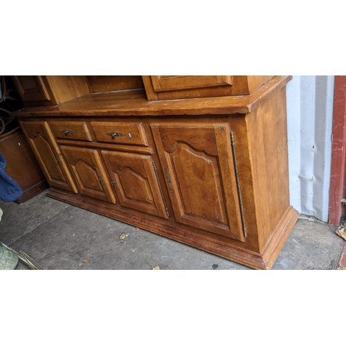 217 - A reproduction French oak large dresser having a moulded cornice, open shelves, six cupboard doors a... 