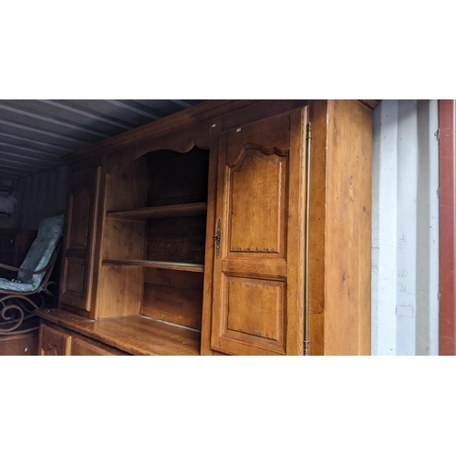 217 - A reproduction French oak large dresser having a moulded cornice, open shelves, six cupboard doors a... 