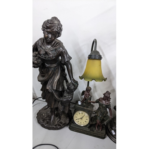 222 - A vintage resin figural table lamp in the form of a lady, boy and dog with two wary rimmed shades, 5... 