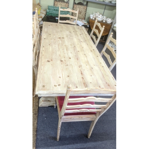 50 - A modern pine dining table on turned legs, united by stretcher, six matching chairs with red upholst... 