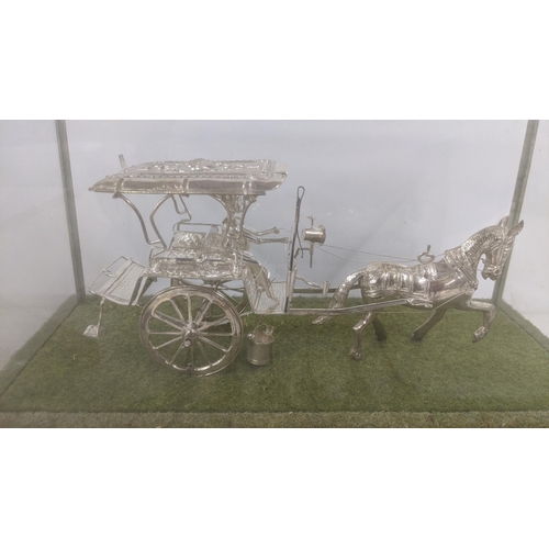 55 - An Indian silver coloured metal model of a horse and carriage in a case
Location: 7.1
If there is no... 