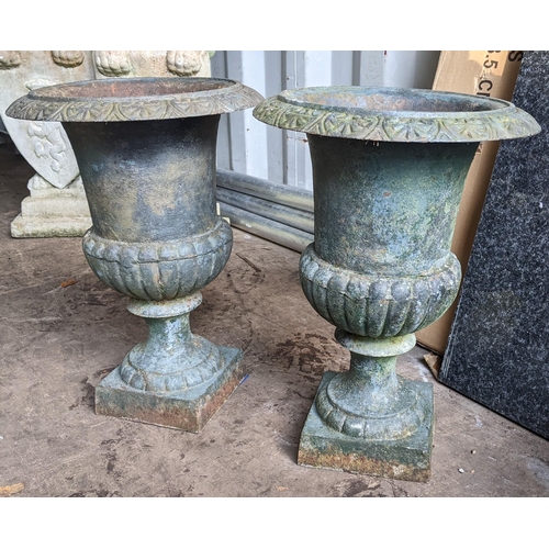 77 - A pair of cast iron planters in the form of Grecian urns with reeded bodies and on square bases, 45c... 