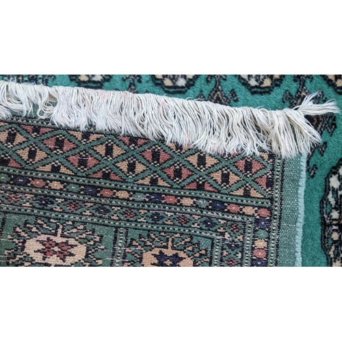 82 - A Pakistani had woven green ground rug having elephant foot motifs and tasselled ends, 151cm x 92cm
... 