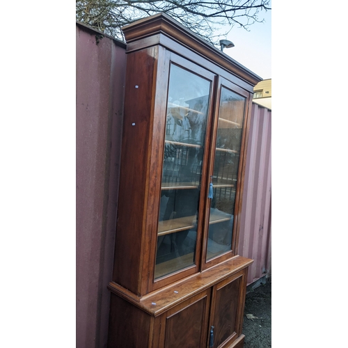 89 - A Victorian mahogany display bookcase having a moulded cornice, two glazed doors and two panelled do... 