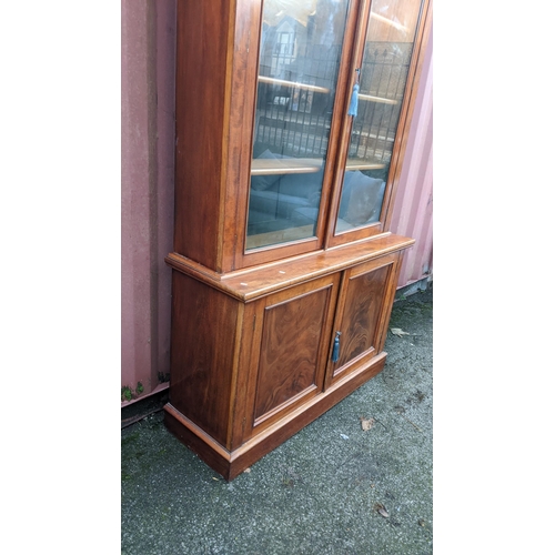 89 - A Victorian mahogany display bookcase having a moulded cornice, two glazed doors and two panelled do... 