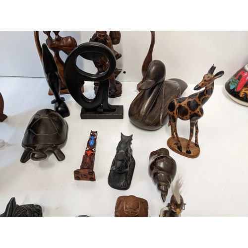 140 - A collection of treen carved figures to include turtles, a duck, a giraffe, a dolphin, a Bhuppa, and... 