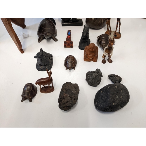 140 - A collection of treen carved figures to include turtles, a duck, a giraffe, a dolphin, a Bhuppa, and... 