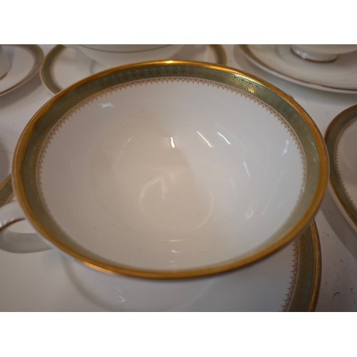 200 - A Royal Doulton 'Clarendon' part dinner service having a white ground with gold design to the rim to... 