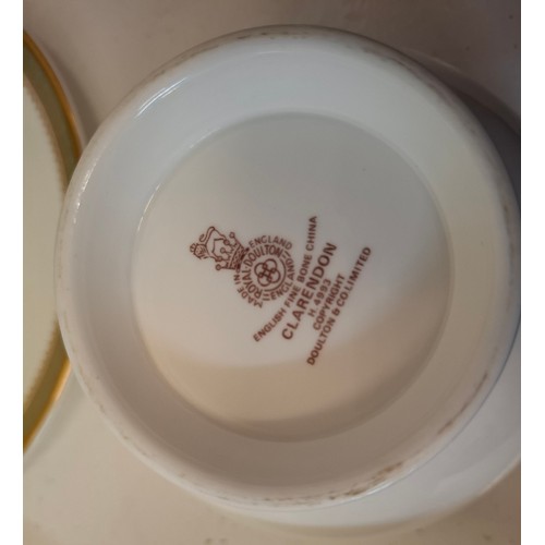 200 - A Royal Doulton 'Clarendon' part dinner service having a white ground with gold design to the rim to... 