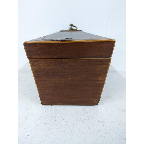 32 - An early 20th century mahogany tea caddy of sarcophagus form with a hinged lid, revealing two interi... 