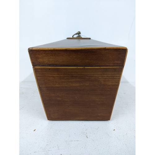 32 - An early 20th century mahogany tea caddy of sarcophagus form with a hinged lid, revealing two interi... 