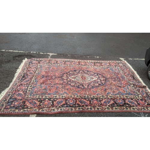 324 - A handwoven Persian design Tabriz rug on a blue and black ground, triple guard boarder with tasselle... 