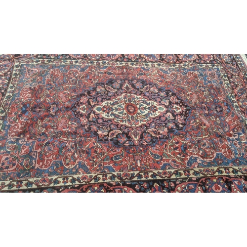 324 - A handwoven Persian design Tabriz rug on a blue and black ground, triple guard boarder with tasselle... 