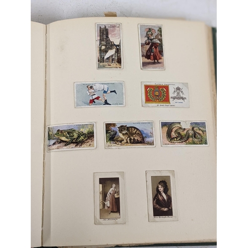 336 - A stamp album containing cigarette cards, pencil sketches and card cut-outs, a Mabel Lucie Attwell c... 