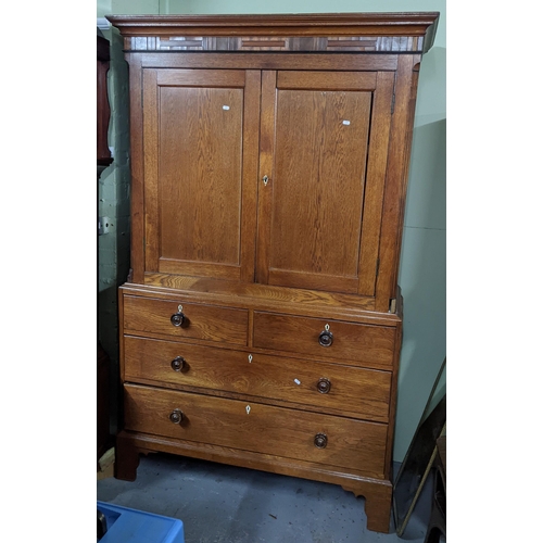 354 - A 19th century oak linen press having a stepped cornice above two cupboard doors and four drawers 20... 