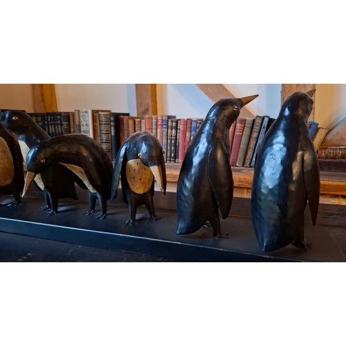 198 - A black and cream metal display of 7 penguins. in various positions, approx 80cm wide x 26cm high Lo... 