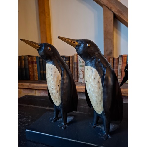 198 - A black and cream metal display of 7 penguins. in various positions, approx 80cm wide x 26cm high Lo... 