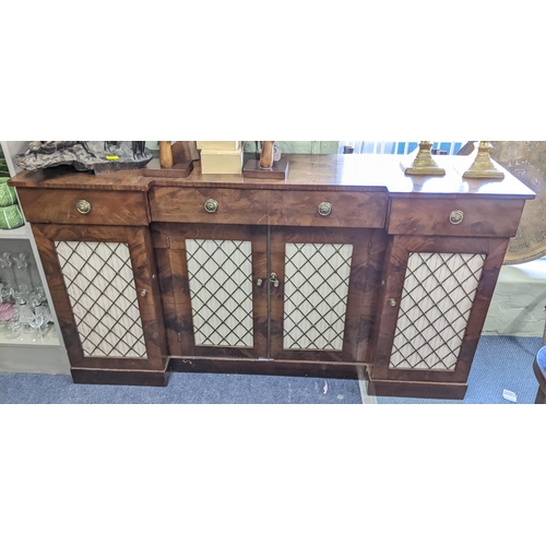 440 - A Regency mahogany break front sideboard having three drawers above four doors with pierced grille f... 