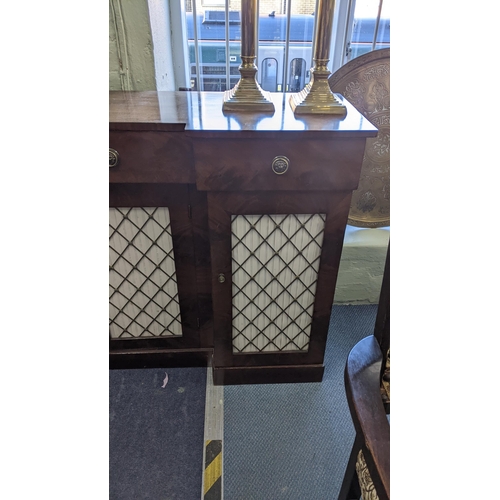 440 - A Regency mahogany break front sideboard having three drawers above four doors with pierced grille f... 