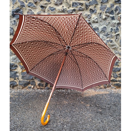 YSL- A mid 20th Century brown and cream branded umbrella having a cane handle. Location:
If there is no condition report, please request.