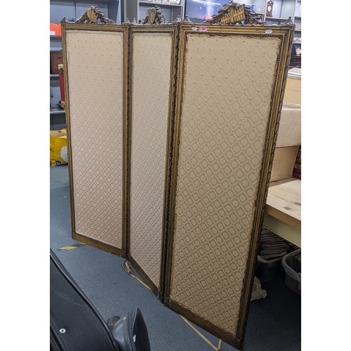 90 - A late 19th century French gilt folding three fold screen, having beige upholstery panels surrounded... 