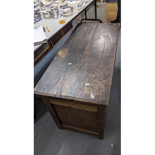 142 - A late 17th century oak coffer having a hinged top with a carved panelled front, 61cm h x 107cm w
Lo... 