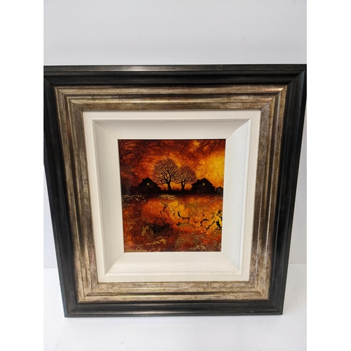 175 - A framed Kerry Darlington signed acrylic on board depicting two houses and two trees in an amber bac... 