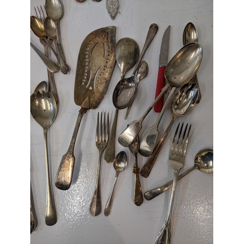 183 - A collection of silver plated flatware to include two pairs of tongs, a fish slice along with mother... 